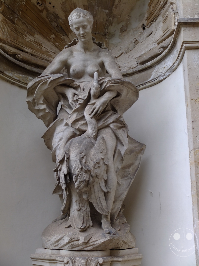 Deutschland - Dresden - Zwinger- Nymphenbad - Steinskulptur zeigt stehende Figur mit Schwan, detailreich, vor architektonischem Element.