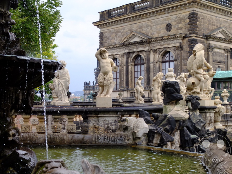Deutschland Dresden - Zwinger- Historisches Barockgebäude mit reich verzierter Fassade und Skulpturen um einen Brunnen.