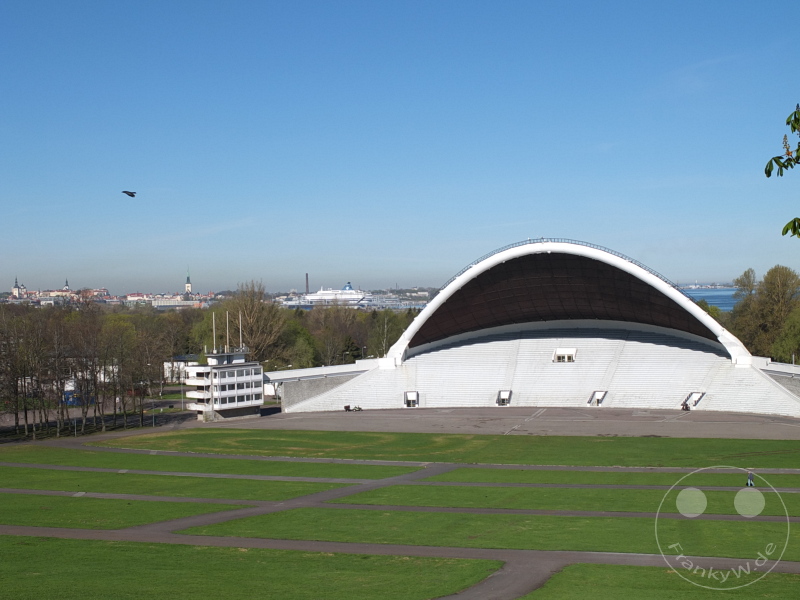 Estland - Tallinn - Großes Freilufttheater mit gewölbter Bühne vor Skyline und Wasserbereich bei klarem Himmel.