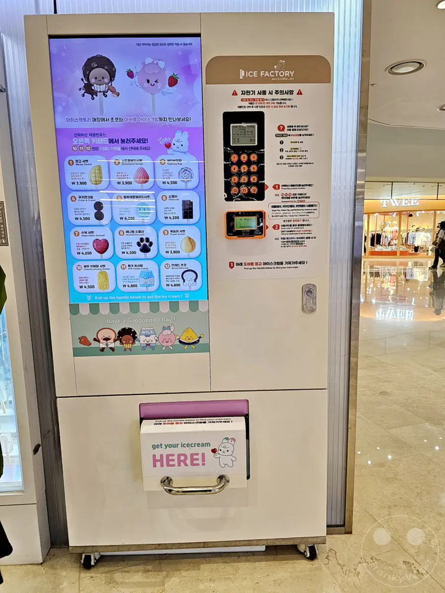 Ein Eisautomat mit bunter Produktvielfalt steht in der Starfield Coex Mall in Gangnam, Seoul, Südkorea. Die digitale Anzeige präsentiert verschiedene Eissorten mit Preisen und Bildern, während daneben Anweisungen zur Bedienung und Sicherheitshinweise in koreanischer Sprache aufgeführt sind. Der Automat verspricht ein süßes Erlebnis für Kunden, die sich in dem belebten Einkaufszentrum befinden.