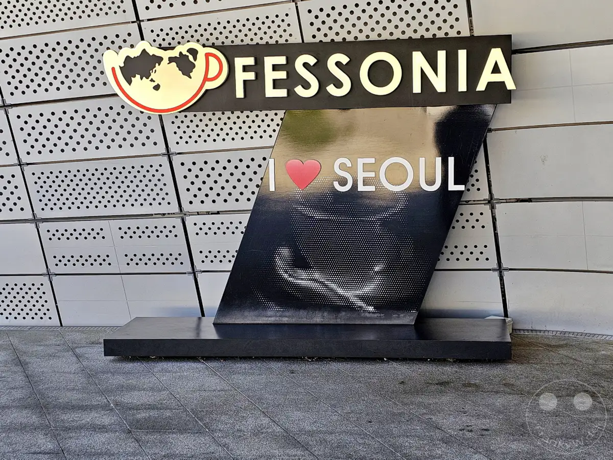 Am Dongdaemun Design Plaza (DDP) in Seoul, Südkorea, prangt die leuchtende Aufschrift "I SEOUL U" über einem stilisierten Herz. Das moderne Wahrzeichen mit seiner futuristischen Architektur bildet einen markanten Kontrast zur umgebenden urbanen Landschaft. Die Beleuchtung des Schriftzugs fängt das Licht ein und schafft eine einladende Atmosphäre in der pulsierenden Metropole.