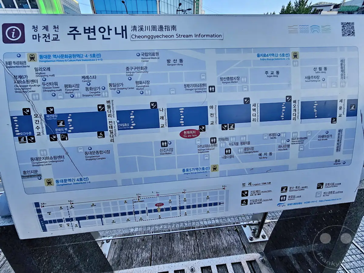 Ein umfassender Stadtplan in Seoul, Südkorea, konzentriert sich auf die Orientierung entlang des Cheonggyecheon Streams und umliegender U-Bahn-Stationen. Die Karte enthält detaillierte Informationen zu Sehenswürdigkeiten, Einkaufszentren und öffentlichen Einrichtungen, um Besuchern bei der Navigation zu helfen. Die klare Darstellung und die Legende ermöglichen eine effiziente Erkundung des Gebiets.