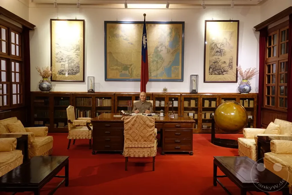 Imposante Nachbildung eines Büroraums im Chiang Kai-shek Memorial Hall in Taipeh, Taiwan. Ein Wachsfiguren-Ensemble stellt den ehemaligen Präsidenten an seinem Schreibtisch dar, umgeben von historischen Artefakten und Karten. Die Szene vermittelt eine feierliche und geschichtsträchtige Atmosphäre, die an die politische Vergangenheit Taiwans erinnert.