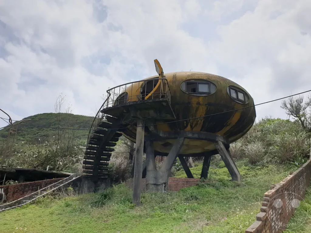 In Taiwan, nahe Wanli, liegt das verlassene UFO Village mit seinen einzigartigen Futuro-Häusern. Die futuristischen Gebäude, einst als Ferienhäuser konzipiert, sind heute vom Verfall gezeichnet und strahlen eine melancholische Atmosphäre aus. Die runde Architektur hebt sich von der üppigen, grünen Umgebung ab und lässt die Fantasie über vergangene Zeiten und zukünftige Visionen schweifen.