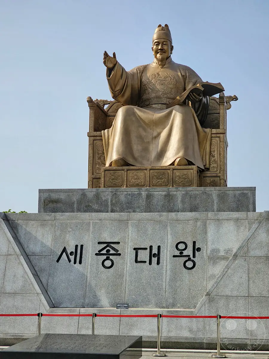 Die Statue von König Sejong dem Großen thront über dem Gwanghwamun-Platz in Seoul, Südkorea. Das beeindruckende Monument ehrt den Schöpfer des koreanischen Alphabets Hangeul. Eine erhabene Atmosphäre umgibt die historische Darstellung des bedeutenden Monarchen.