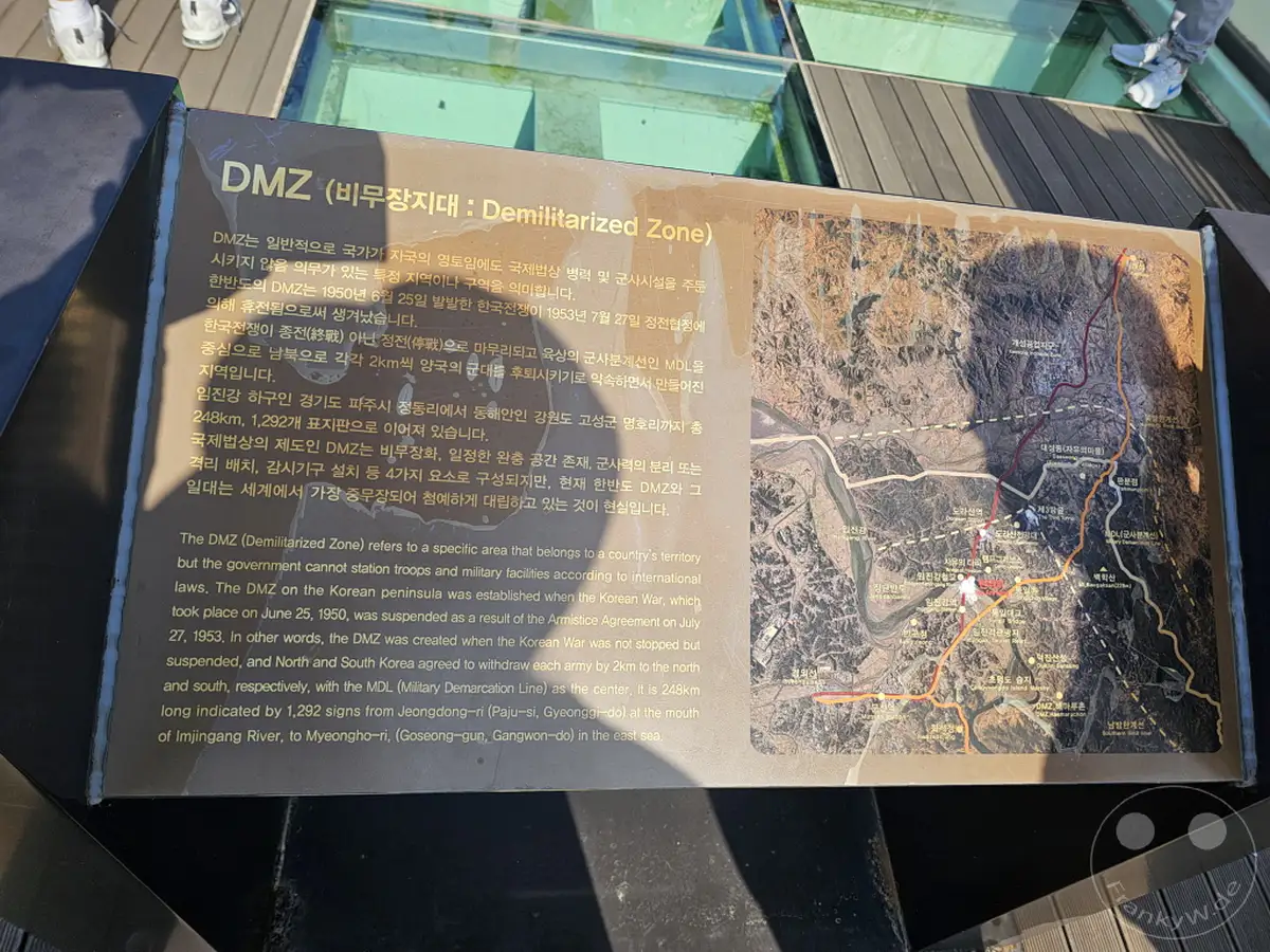 Eine Informationstafel über die Demilitarisierte Zone (DMZ) in Südkorea gibt Einblicke in die Geschichte des Koreakriegs und die heutige Situation an der Grenze. Die Tafel ist mit einer Karte der Region versehen, die die strategische Bedeutung des Gebiets verdeutlicht. Das kühle, sachliche Design des Informationsmaterials spiegelt die Ernsthaftigkeit des Themas wider.