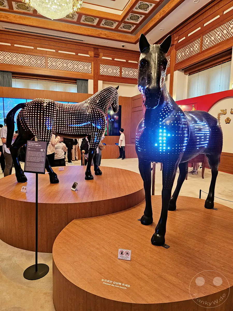 Im Herzen von Seoul, Südkorea, stehen im ehemaligen Präsidentenpalast von Das Blaue Haus (Cheongwadae) beeindruckende LED-Skulpturen von Pferden. Die Kunstinstallation erhellt den Raum mit ihren leuchtenden Mustern und schafft eine moderne und fesselnde Atmosphäre inmitten historischer Architektur. Besucher werden gebeten, die Exponate lediglich mit den Augen zu genießen.