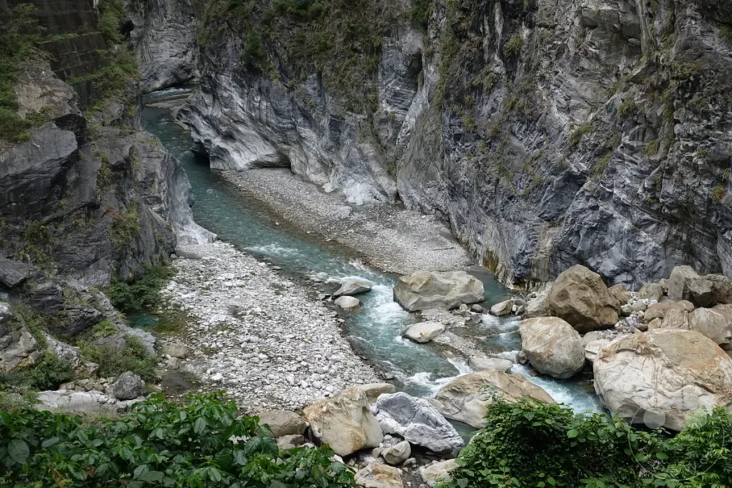 Der Liwu River schlängelt sich durch die steilen Felswände des Taroko Nationalparks in Taiwan. Das türkisfarbene Wasser kontrastiert mit den grauen, zerklüfteten Felsen, die von üppiger Vegetation durchzogen sind. Eine majestätische und wilde Naturlandschaft, die die Kraft der Erosion über Jahrtausende hinweg eindrucksvoll zur Schau stellt.