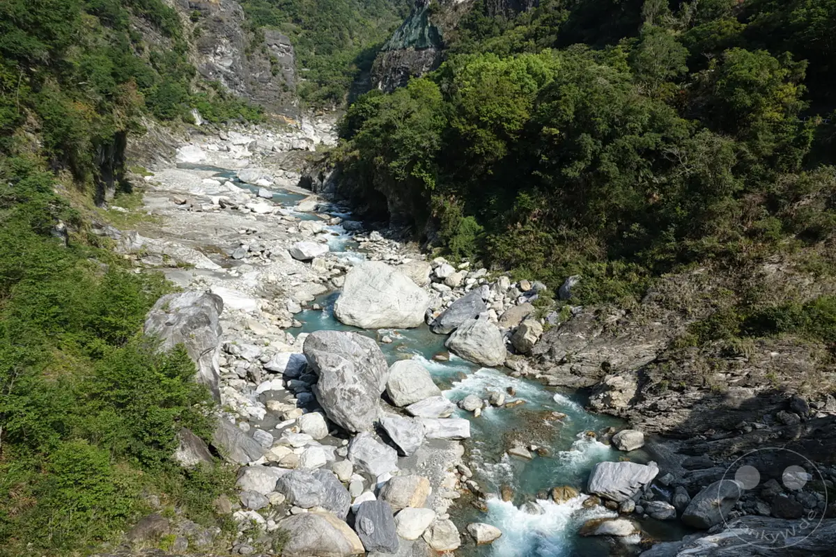Der Taroko-Nationalpark in Taiwan beeindruckt mit der dramatischen Landschaft der Yuewangting-Schlucht. Ein türkisfarbener Fluss schlängelt sich durch das Tal, gesäumt von imposanten Marmorformationen und üppiger Vegetation. Die Szenerie strahlt eine urtümliche und friedliche Atmosphäre aus, die zum Verweilen einlädt.