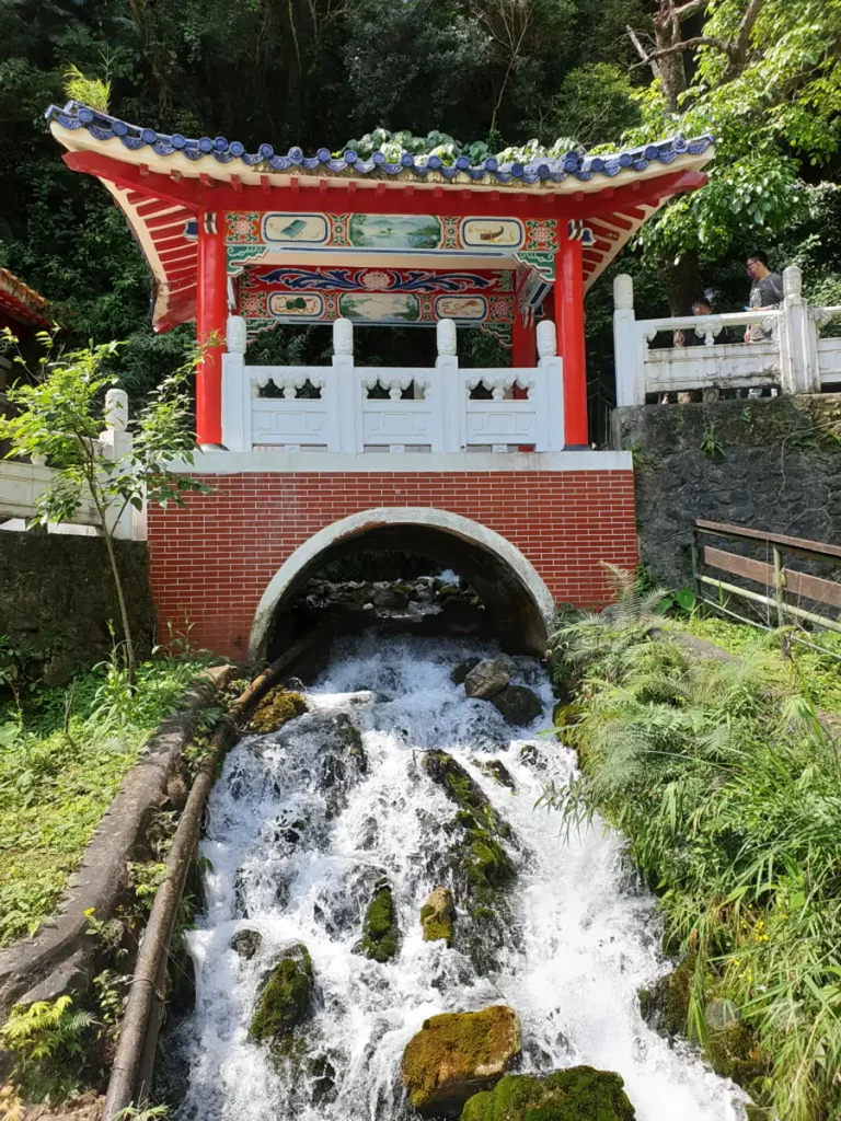 In Taiwan, im Taroko Nationalpark, befindet sich der Changchun Shrine, der über einem rauschenden Wasserfall thront. Die traditionelle chinesische Pagode mit ihren roten Säulen und verzierten Dächern bildet einen faszinierenden Kontrast zur umgebenden üppigen Natur. Die Szene strahlt eine friedliche und zugleich kraftvolle Atmosphäre aus, die die harmonische Verbindung von Architektur und Landschaft einfängt.