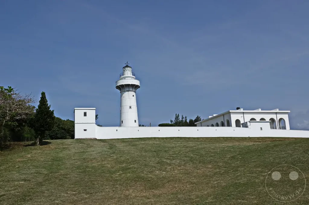 Der Eluanbi Leuchtturm auf Taiwan ragt stolz in den klaren blauen Himmel, umgeben von weißen Gebäuden und üppigem Grün. Die imposante Struktur dient seit Jahrzehnten als wichtiger Orientierungspunkt für Schiffe und strahlt eine ruhige, aber beständige Präsenz aus. Die weite Grasfläche im Vordergrund lädt zum Verweilen ein und unterstreicht die majestätische Kulisse dieses Küstenwächters.