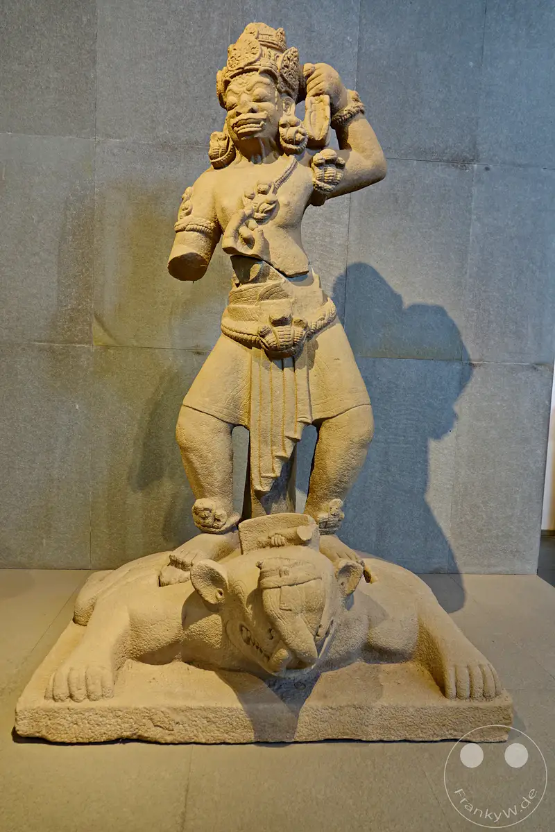 In Da Nang, Vietnam, steht im Museum of Cham Sculpture eine beeindruckende Cham-Statue aus Stein. Sie stellt eine Gottheit dar, die mit kraftvoller Haltung und detaillierter Ausarbeitung auf einem liegenden Tier thront. Die Darstellung strahlt eine Aura von alter Macht und spiritueller Bedeutung aus.