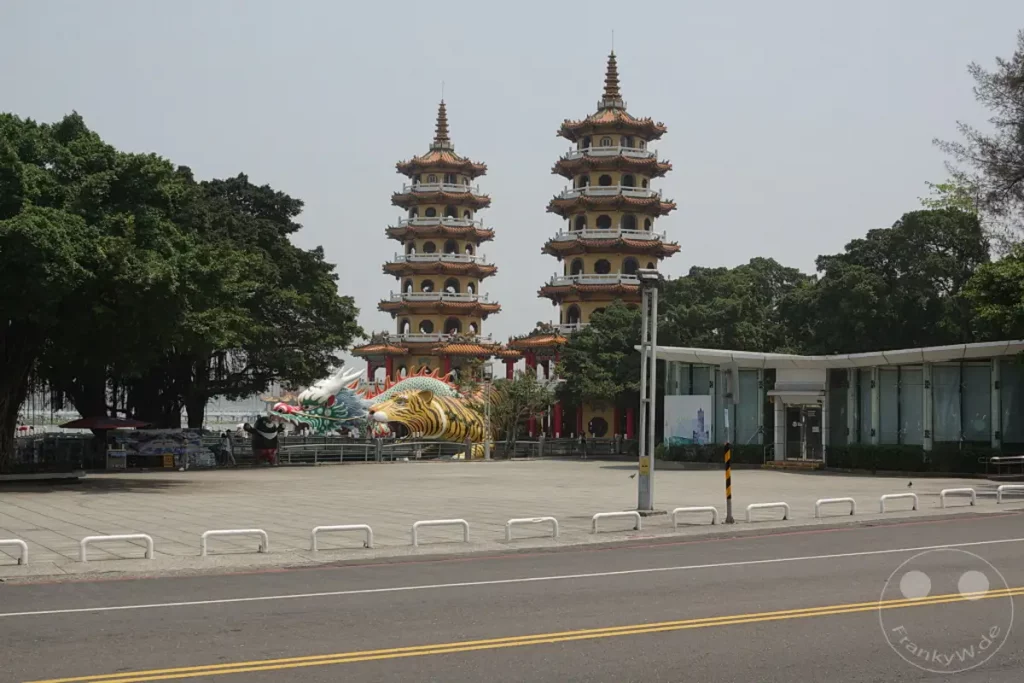 Die majestätischen Drachen- und Tigerpagoden von Zuoying in Taiwan sind ein beeindruckendes Wahrzeichen. Diese kunstvoll gestalteten Bauwerke ziehen Besucher mit ihrer bunten Symbolik und architektonischen Pracht an. Die Szene strahlt eine kulturelle und spirituelle Atmosphäre aus, umgeben von üppigem Grün und einem weiten Platz.