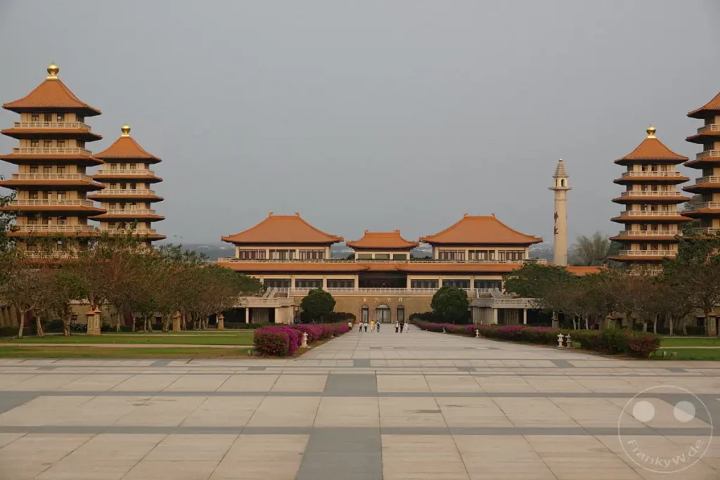 Der Fo Guang Shan Buddha Museum Komplex in Kaohsiung, Taiwan, präsentiert eine beeindruckende Architektur mit traditionellen chinesischen Pagoden und weitläufigen Höfen. Die symmetrische Anlage und die ruhige Atmosphäre laden zum Verweilen und zur Besinnung ein. Zahlreiche Besucher erkunden das Gelände unter einem weiten, grauen Himmel.