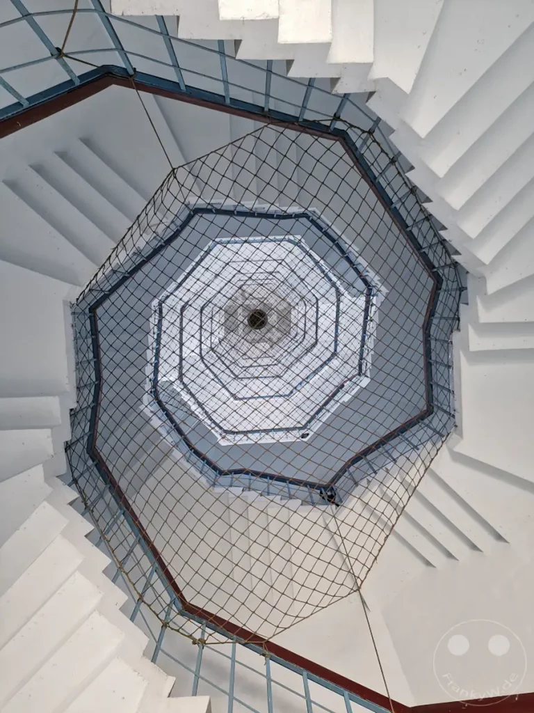 Das spiralförmige Treppenhaus der Ci'en Pagoda am Sun Moon Lake in Taiwan bietet eine faszinierende Perspektive. Die geometrischen Linien und die symmetrische Konstruktion erzeugen ein Gefühl der Tiefe und unendlichen Weite. Das Licht, das von oben durch den Schacht fällt, beleuchtet die weißen Stufen und verleiht der Szene eine ruhige und gleichzeitig eindringliche Atmosphäre.