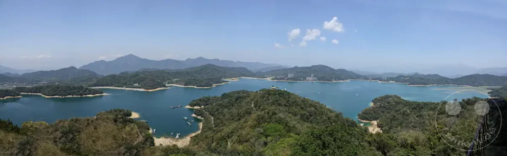 Die Ci'en Pagode thront über dem malerischen Sun Moon Lake in Taiwan, umgeben von üppigen, grünen Bergen. Die ruhige Wasserfläche spiegelt den blauen Himmel und die sanften Hügel, was eine friedliche und idyllische Atmosphäre schafft. Diese Panoramaaussicht bietet einen atemberaubenden Blick auf die natürliche Schönheit und die kulturellen Wahrzeichen der Region.