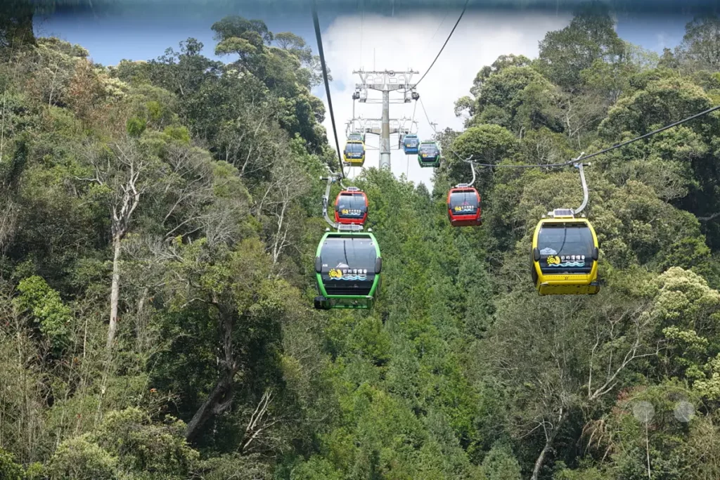 Mehrere bunte Gondeln der Riyuetanlan Ropeway Station schweben über einem üppigen, von Bäumen bedeckten Berghang am Sun Moon Lake in Taiwan. Die Sonneneinstrahlung hebt die lebendigen Farben der Gondeln und die dichte Vegetation hervor und vermittelt ein Gefühl von Abenteuer und Entspannung in der Natur. Die Seilbahn bietet einen atemberaubenden Panoramablick auf die umliegende Landschaft.