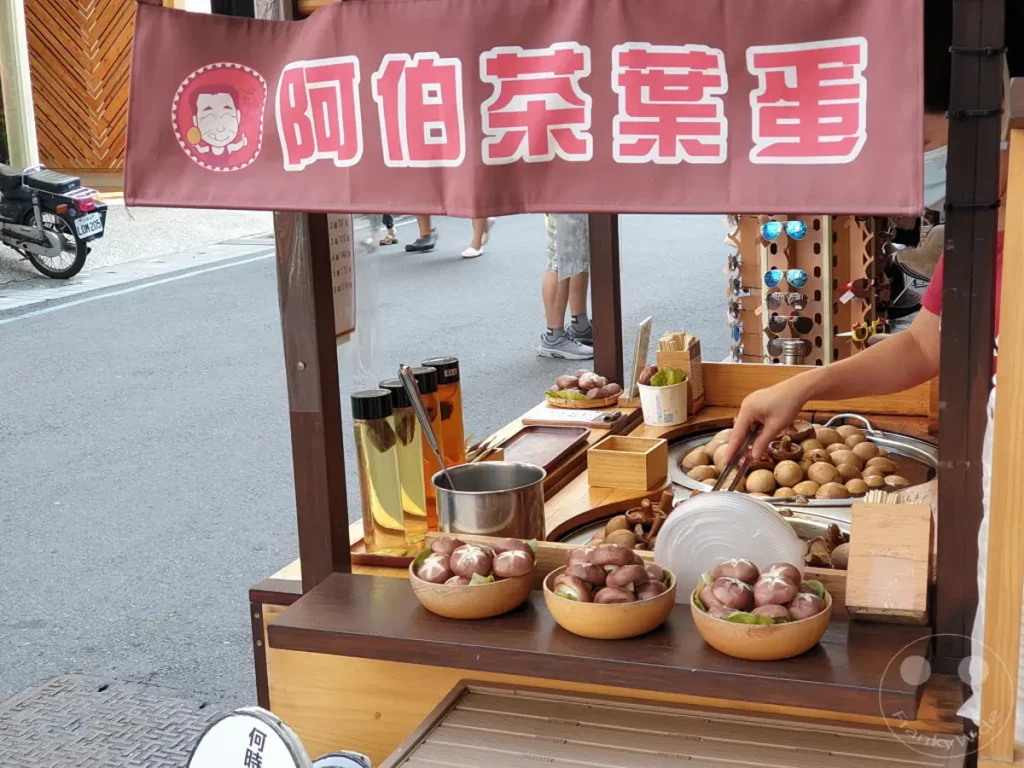 In Shuishe am Sun Moon Lake in Taiwan werden auf einem Marktstand frisch zubereitete Pilzgerichte angeboten. Die dampfenden Speisen verströmen einen appetitlichen Duft und laden Passanten zum Probieren ein. Die Szene strahlt die lebendige Atmosphäre eines lokalen Marktes aus, der traditionelle Köstlichkeiten feiert.