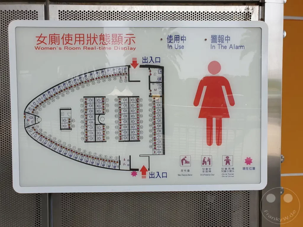 Die Fotografie präsentiert eine digitale Anzeige an einer Autobahnraststätte in Taichung, Taiwan, die den Belegungsstatus der Damentoiletten visualisiert. Verschiedene Symbole und eine schematische Darstellung des Grundrisses informieren über die Verfügbarkeit der einzelnen Kabinen. Die klare und funktionale Gestaltung unterstreicht die Effizienz und Übersichtlichkeit der Einrichtung.