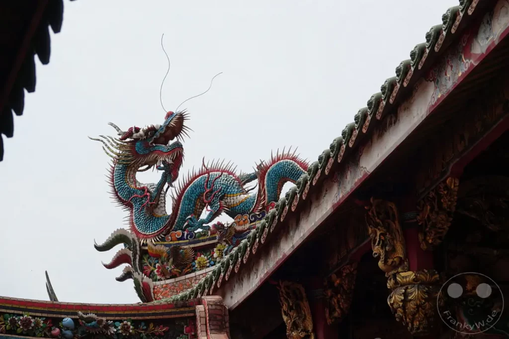 Eine farbenprächtige Drachenskulptur ziert das Dach des Mengjia Longshan Tempels in Taipeh, Taiwan. Die kunstvolle Verzierung aus Keramik und anderen Materialien spiegelt traditionelle chinesische Architektur wider. Das detailreiche Kunstwerk, das sich über die Dachkante erhebt, vermittelt einen Eindruck von religiöser Pracht und kultureller Tiefe.