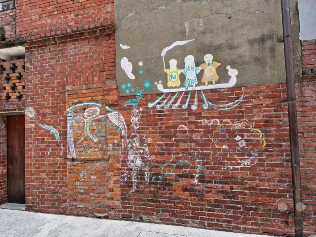 In Taipeh, Taiwan, präsentiert sich der Bopiliao Historical Block mit farbenfroher Wandmalerei. Verschiedene bunte Darstellungen von Figuren und Schiffen schmücken die Ziegelmauern und schaffen eine lebendige Atmosphäre. Die Street Art verbindet historische Elemente mit moderner Kunst und belebt das historische Viertel.