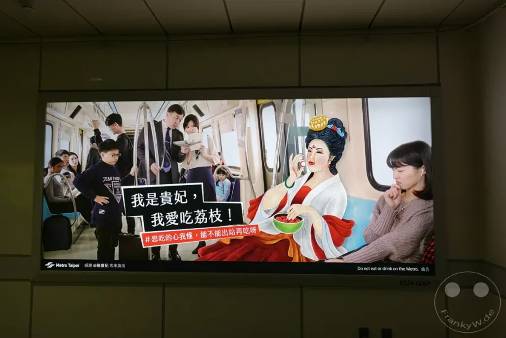Eine Werbetafel im Metro Taipeh System zeigt eine Mischung aus traditioneller und moderner Kultur, die auf die Regeln des öffentlichen Nahverkehrs hinweist. Eine stilisierte Darstellung einer historischen chinesischen Figur, die symbolisch für eine "Edle Frau" steht, wird mit einer Botschaft über das Verbot von Essen und Trinken im Zug kombiniert. Die Szene soll humorvoll auf das Verhalten der Fahrgäste aufmerksam machen und die kulturellen Unterschiede in der öffentlichen Etikette thematisieren.