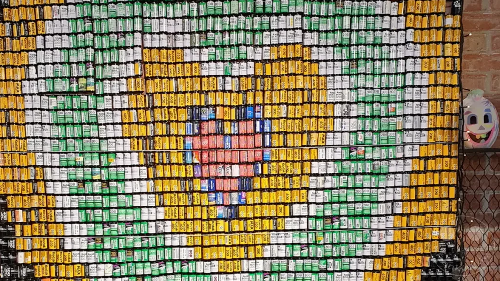Eine beeindruckende Kunstinstallation aus Filmrollen bildet ein stilisiertes Herz und andere Muster vor der Kulisse des The Red House in Taipehs Xinmen District in Taiwan. Die bunten Filmrollen, geordnet nach Farbe und ISO-Wert, schaffen ein visuell fesselndes Mosaik mit nostalgischem Charme. Die Szene strahlt Kreativität und eine Hommage an die analoge Fotografie aus, eingebettet in das lebendige Herz des Stadtviertels.