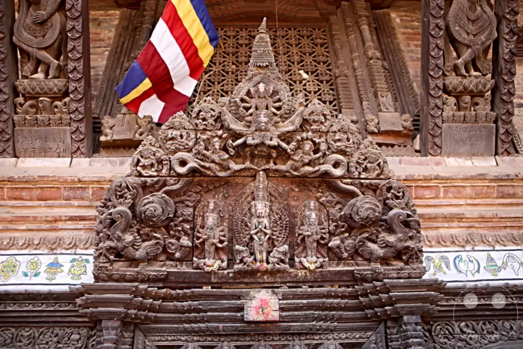 Eine kunstvoll geschnitzte Holzfassade eines Tempels in Bhaktapur, Nepal. Verziert mit buddhistischen Symbolen und Figuren, die die reiche Kultur und Spiritualität des Landes widerspiegeln. Die Detailverliebtheit und das Alter der Schnitzereien erzählen von jahrhundertealter Handwerkskunst.