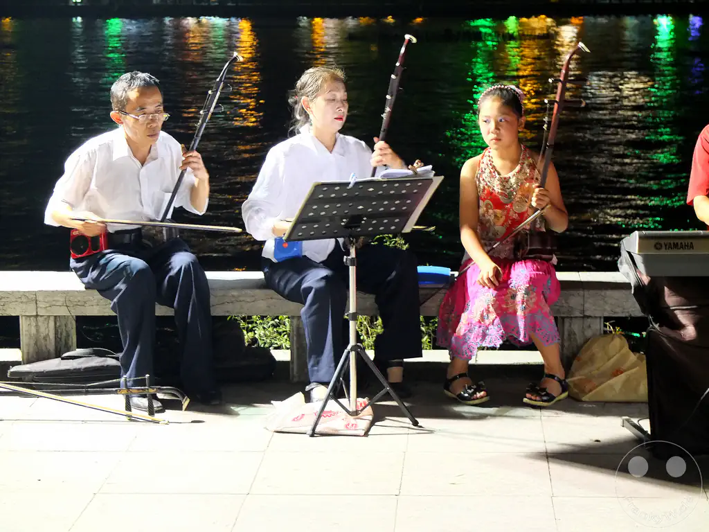 China - Guilin - A group of street musicians playing the erhu, a traditional Chinese string instrument, on the waterfront promenade in Guilin