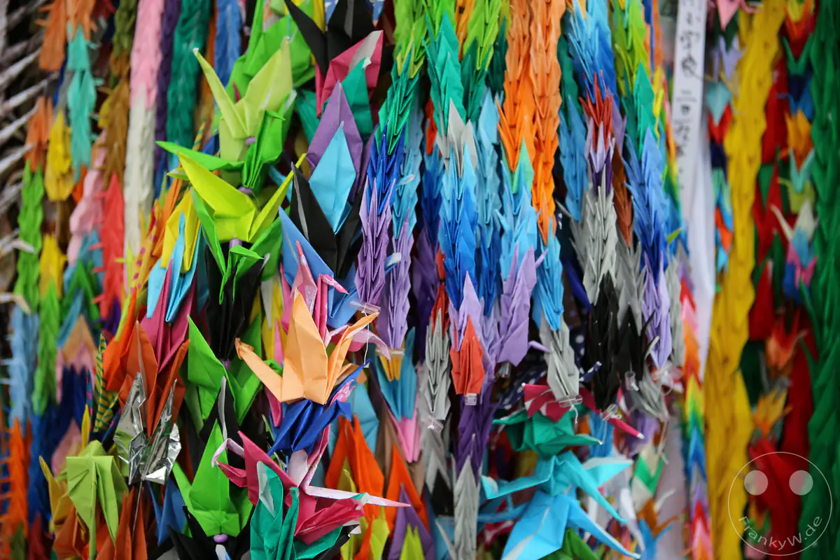 Tausende bunte Origami-Kraniche hängen dicht aneinandergereiht als traditionelles Friedenssymbol und farbenfrohes Mahnmal im Hiroshima-Friedenspark für weltweite Hoffnung.