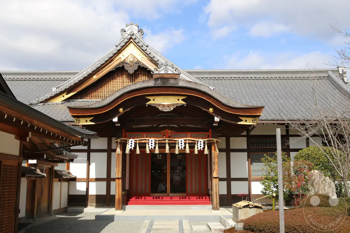 Traditionelles Shamusho-Verwaltungshaus mit geschwungenem Holzdach, kunstvollen Gold-Schnitzereien und Shimenawa-Seil am Fushimi-Inari-Taisha-Schrein in Kyoto, Japan.