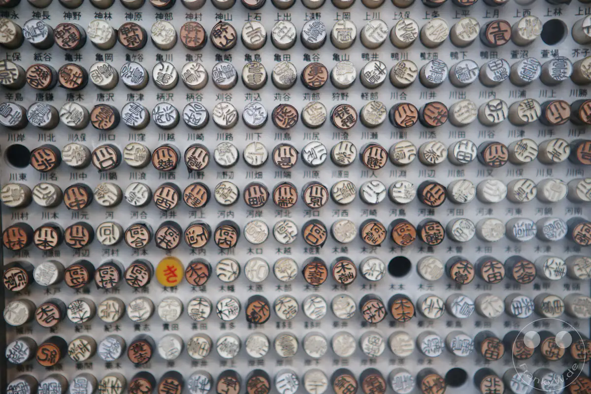 Große Sammlung traditioneller Hanko-Namenssiegel aus Holz und Horn mit japanischen Schriftzeichen in einem Schaukasten in der Nähe des Fushimi-Inari-Taisha-Schrein in Kyoto, Japan.