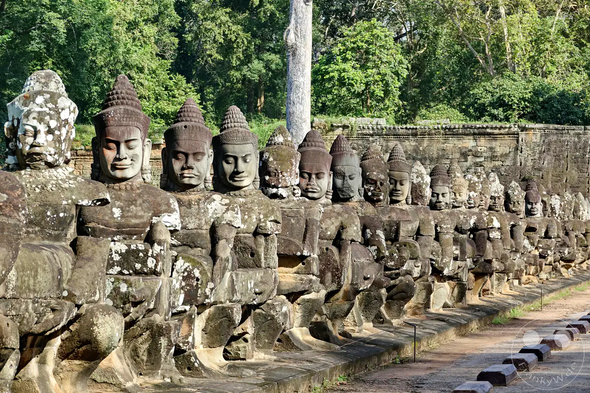Eine Reihe monumentaler Steinstatuen von Göttern und Dämonen auf der Brücke zum Südtor der antiken Stadt Angkor Thom in Kambodscha.