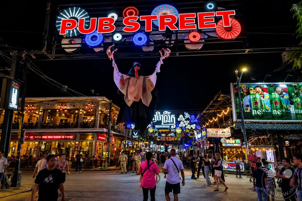 Farbenfrohe Nachtaufnahme der Pub Street in Siem Reap mit Neonlichtern, Restaurants, Bars und Besuchern im Zentrum des kambodschanischen Nachtlebens.