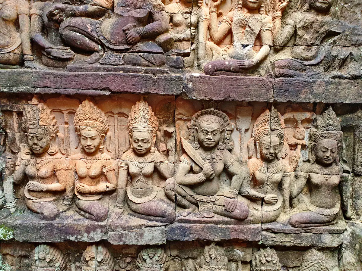 Mehrere Reihen historischer, detailreich in den Stein gemeißelter Reliefs an der versteckten Innenmauer der Terrasse des Lepra-Königs in Angkor Thom mit Darstellungen von Apsaras und mythologischen Figuren.