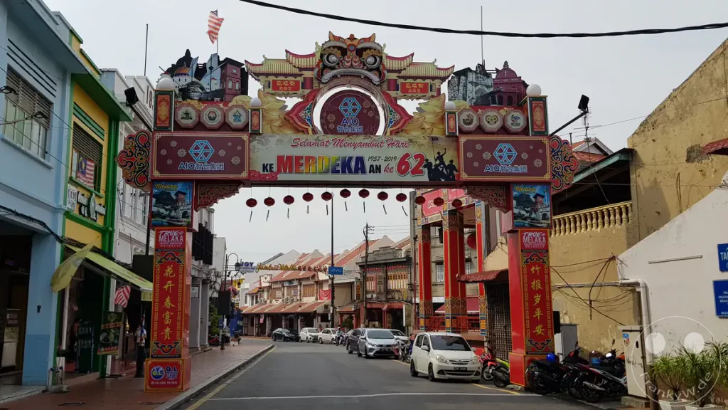 Ein farbenfroher, reich verzierter Torbogen über der Einfahrt zur Jonker Street in der Stadt Melaka, dekoriert mit Glückwünschen zum 62. malaysischen Unabhängigkeitstag (Hari Merdeka).