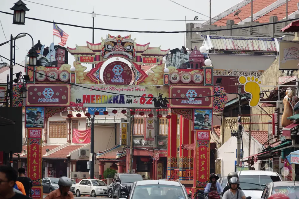 Ein farbenfroher, reich verzierter Torbogen über der Einfahrt zur Jonker Street in der Stadt Melaka, dekoriert mit Glückwünschen zum 62. malaysischen Unabhängigkeitstag (Hari Merdeka).