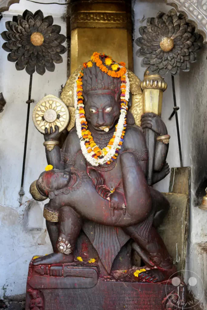 Diese detailreiche Statue zeigt eine Darstellung von Vishnu, wie er die Göttin Lakshmi auf seinem Schoß trägt. Sie befindet sich auf dem Kathmandu Durbar Square und strahlt eine tiefe spirituelle Präsenz aus.