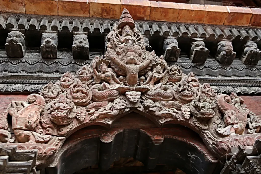 Detailaufnahme einer kunstvollen Holzschnitzerei am Durbar Square in Patan, Nepal. Die filigranen Verzierungen zeigen mythologische Figuren und ornamentale Muster, die die reiche Kultur und Architektur des Landes widerspiegeln.